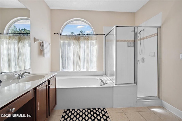 bathroom featuring tile patterned flooring, vanity, a healthy amount of sunlight, and separate shower and tub