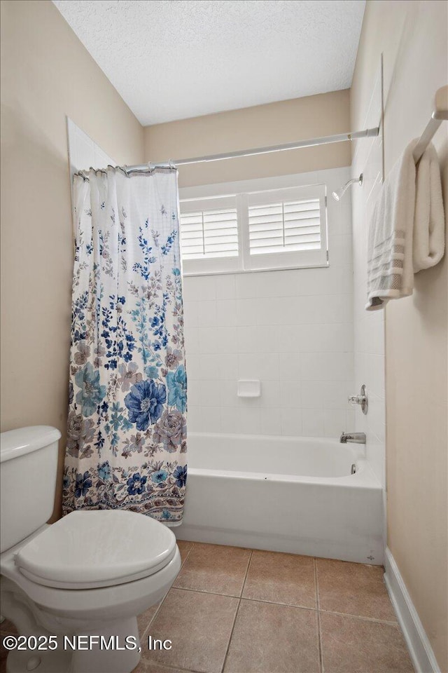 bathroom featuring shower / bath combo with shower curtain, tile patterned floors, toilet, and a textured ceiling