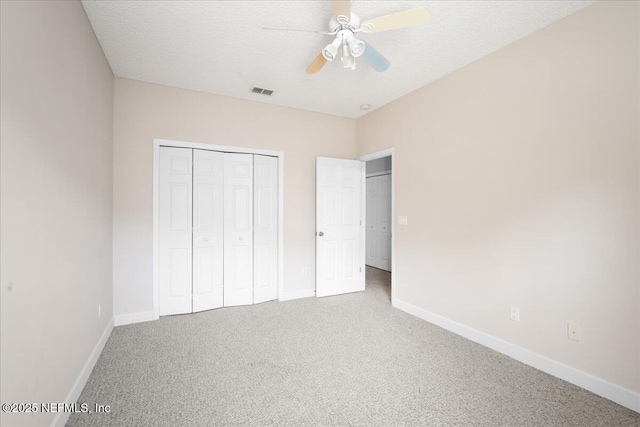 unfurnished bedroom with ceiling fan, carpet floors, a closet, and a textured ceiling