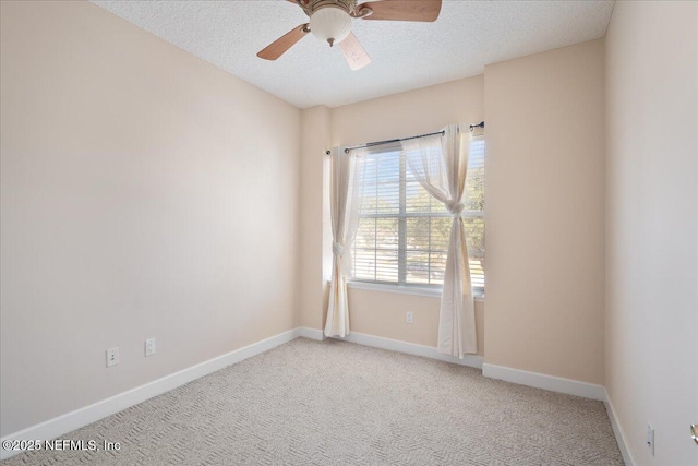 carpeted spare room with ceiling fan and a textured ceiling