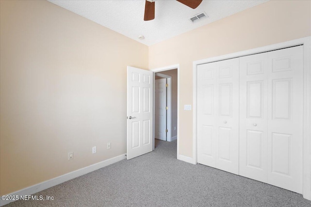 unfurnished bedroom featuring ceiling fan, a closet, carpet, and a textured ceiling