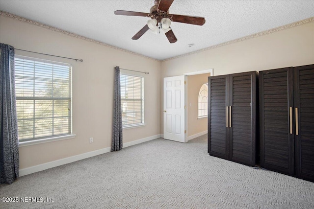 unfurnished bedroom featuring ceiling fan, light colored carpet, and a textured ceiling