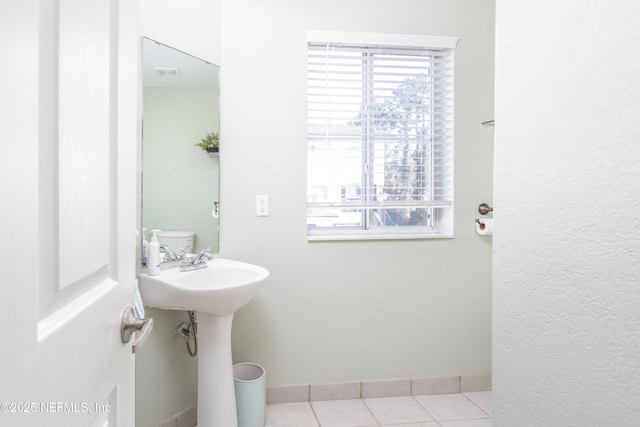 bathroom with tile patterned flooring and toilet