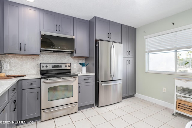 kitchen with gray cabinets, appliances with stainless steel finishes, a textured ceiling, and decorative backsplash