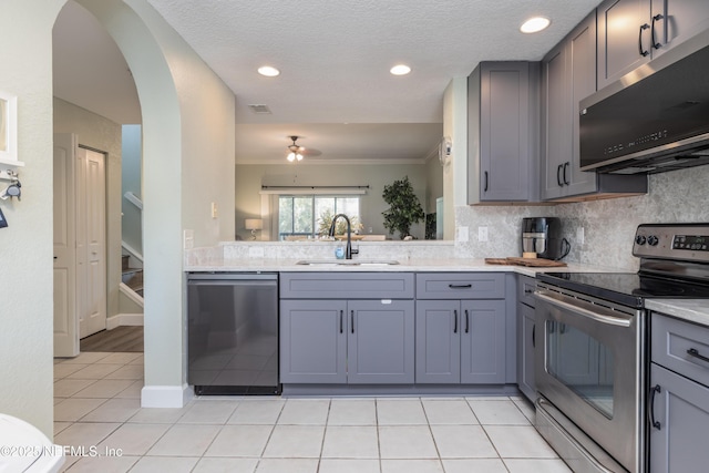 kitchen with gray cabinets, appliances with stainless steel finishes, tasteful backsplash, sink, and light tile patterned floors