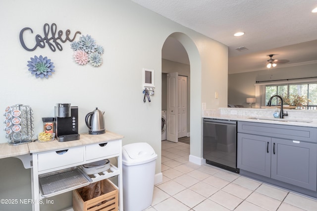 kitchen featuring sink, gray cabinets, light tile patterned flooring, washer / clothes dryer, and stainless steel dishwasher