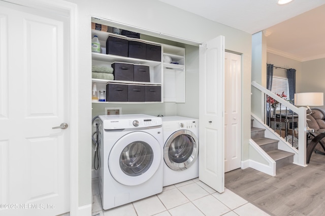 laundry room with light tile patterned floors, ornamental molding, and washer and dryer