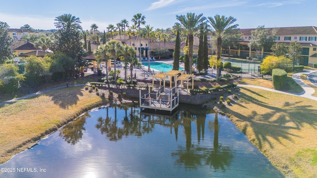 exterior space with a water view, a community pool, and a yard