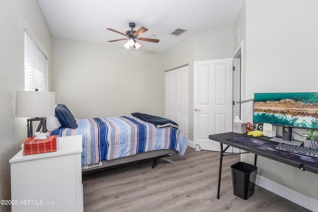 bedroom with hardwood / wood-style floors, a closet, and ceiling fan