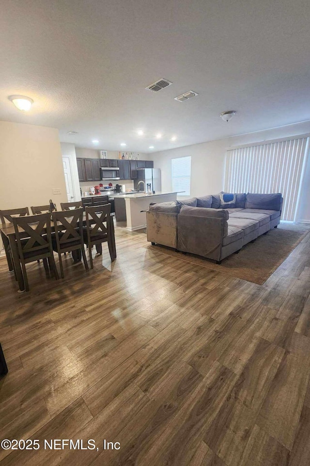 living room with dark wood-type flooring and a textured ceiling