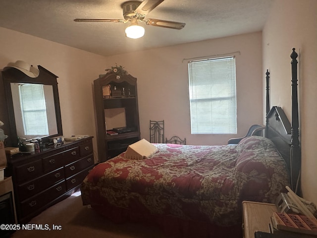 carpeted bedroom with ceiling fan and a textured ceiling