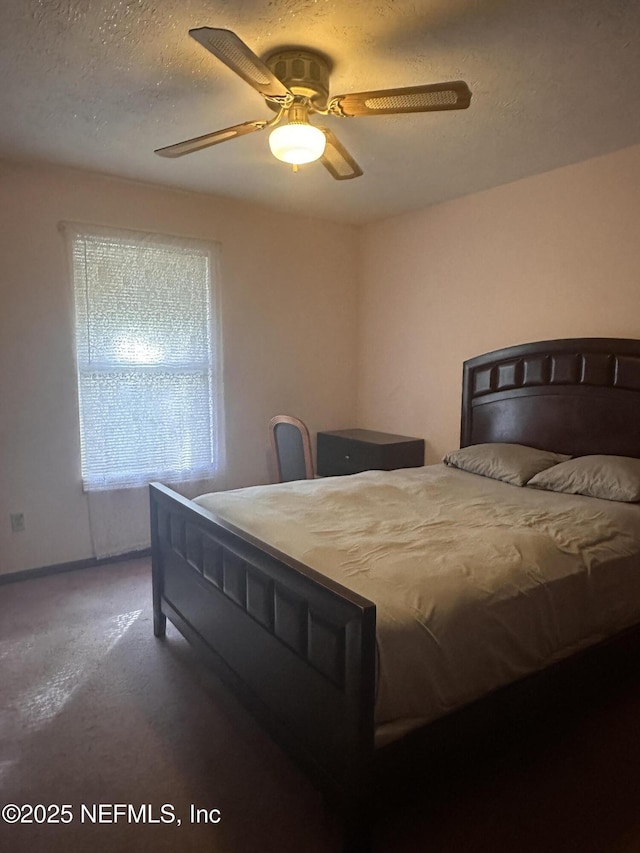 carpeted bedroom with ceiling fan and a textured ceiling