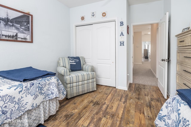 bedroom with dark hardwood / wood-style flooring and a closet