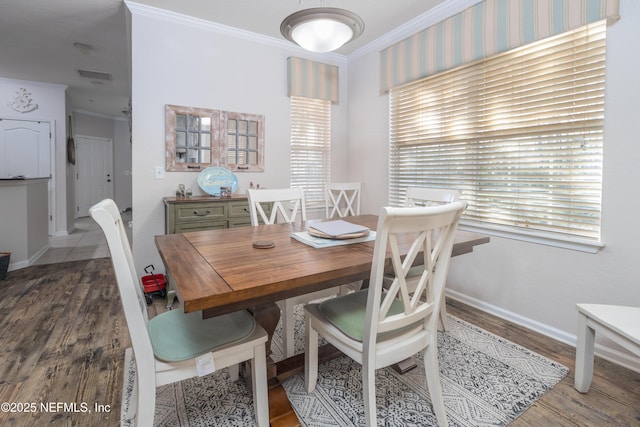 dining area with wood-type flooring and ornamental molding