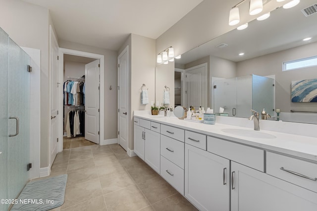 bathroom featuring a shower with door, vanity, and tile patterned floors