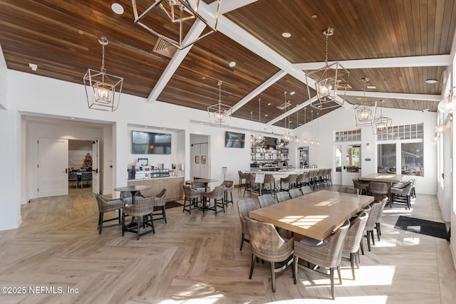 dining space with an inviting chandelier, wood ceiling, and high vaulted ceiling