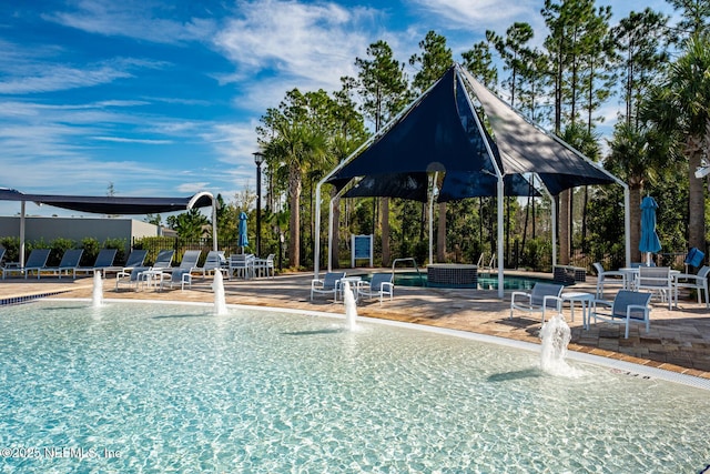 view of swimming pool with pool water feature and a patio area