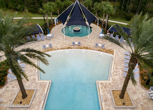 view of swimming pool featuring a community hot tub and a patio