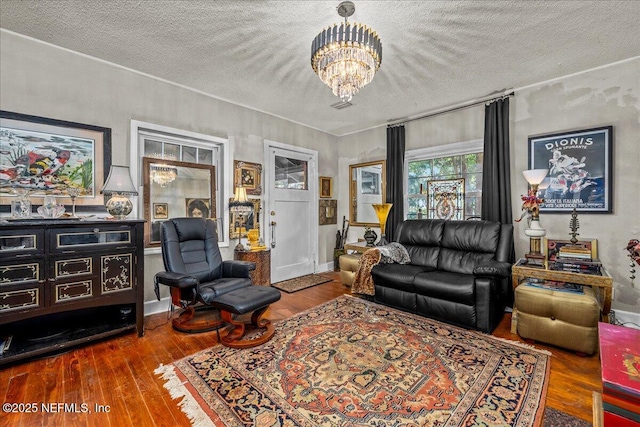 living room with hardwood / wood-style floors, a textured ceiling, and a chandelier