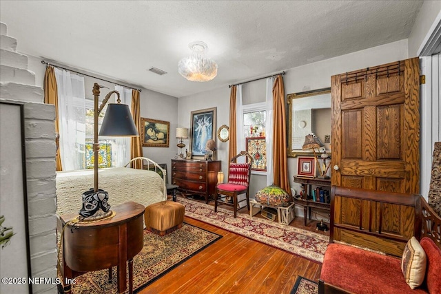 bedroom with hardwood / wood-style floors and a textured ceiling