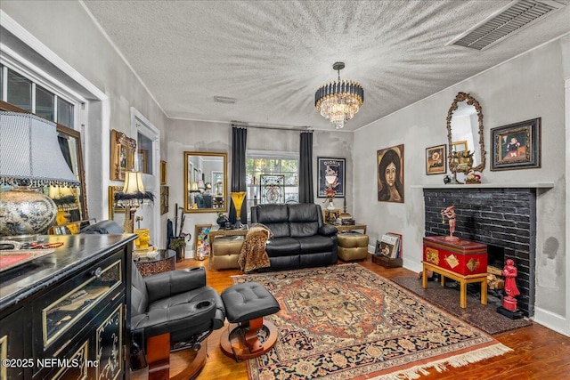 living room featuring ornamental molding, hardwood / wood-style floors, a textured ceiling, and a chandelier