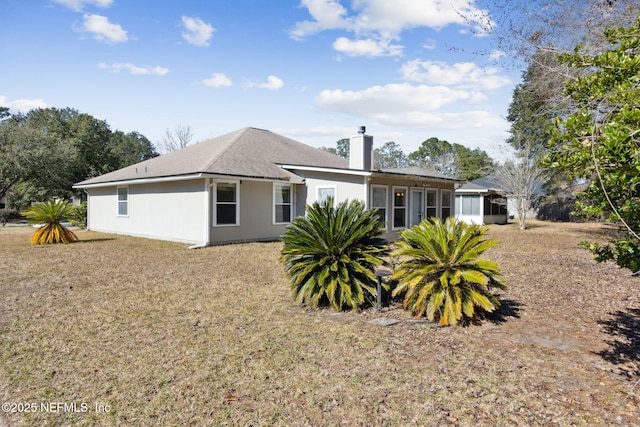 back of property with a sunroom and a yard