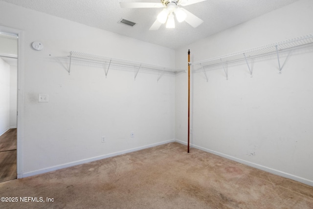 walk in closet with ceiling fan and carpet flooring