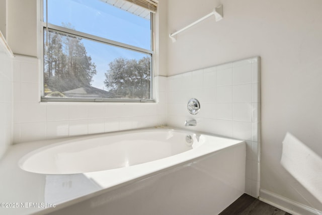 bathroom featuring hardwood / wood-style flooring and a tub to relax in