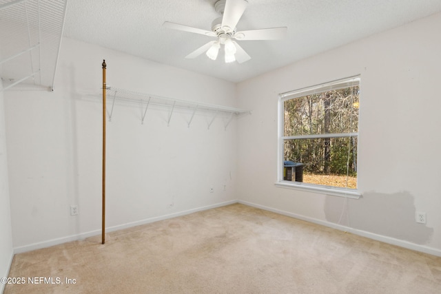 spare room with ceiling fan, light colored carpet, and a textured ceiling