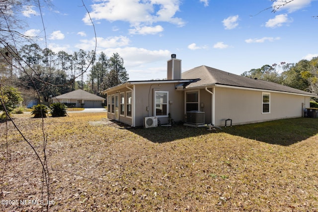 rear view of house with central AC unit, a yard, and ac unit