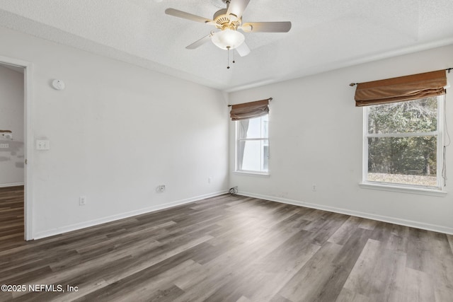 empty room with ceiling fan, dark hardwood / wood-style floors, and a textured ceiling