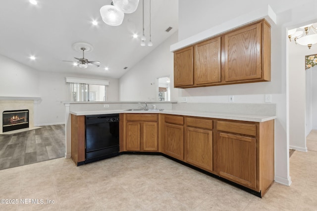 kitchen with sink, hanging light fixtures, black dishwasher, a high end fireplace, and vaulted ceiling