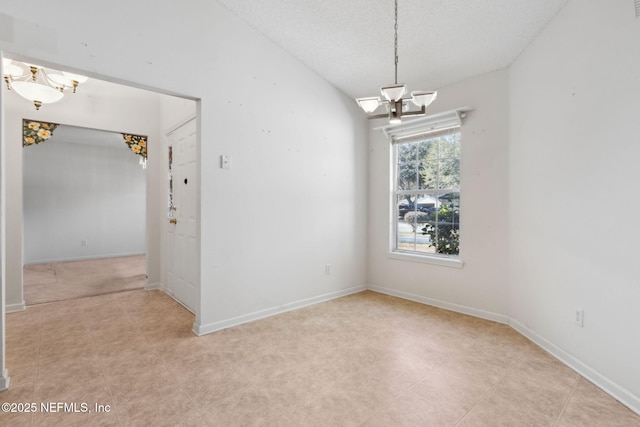 empty room with vaulted ceiling and a chandelier