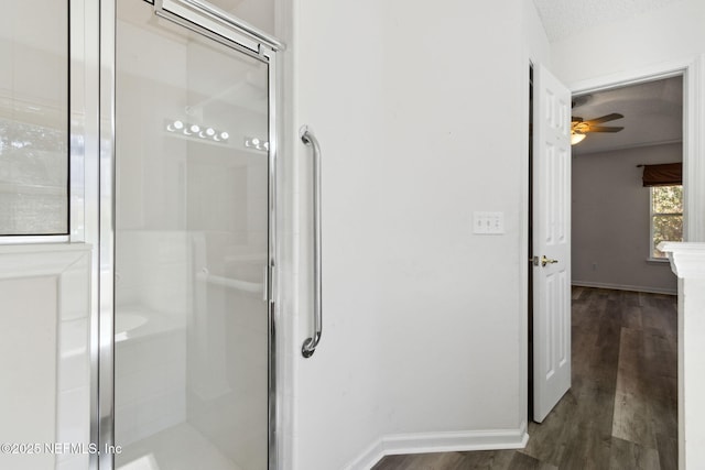 bathroom with an enclosed shower, hardwood / wood-style floors, a textured ceiling, and ceiling fan