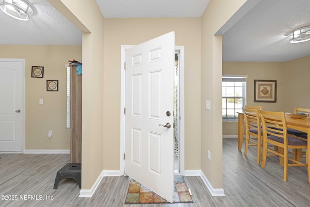 entrance foyer featuring a textured ceiling and light wood-type flooring