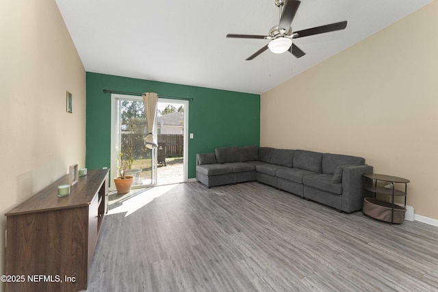 living room featuring ceiling fan, vaulted ceiling, and light hardwood / wood-style flooring