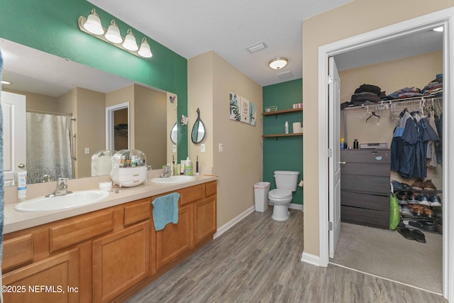 bathroom with vanity, toilet, and wood-type flooring