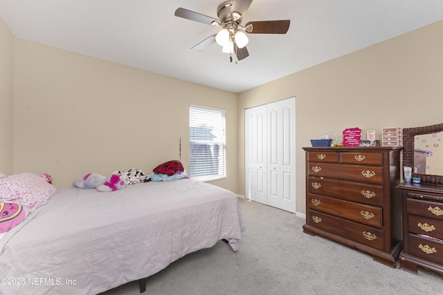 bedroom featuring light carpet, ceiling fan, and a closet