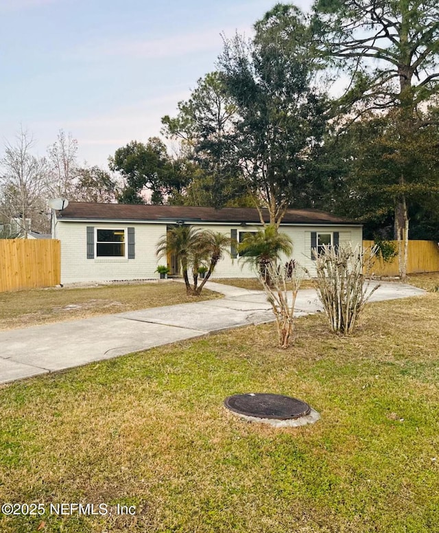 single story home featuring a front lawn