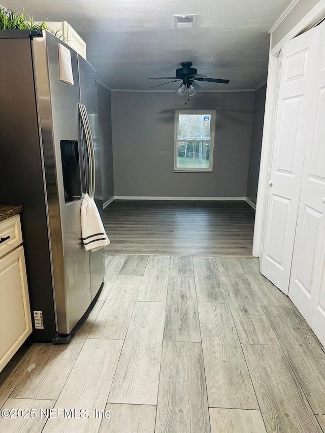 kitchen with ornamental molding, stainless steel fridge, and ceiling fan