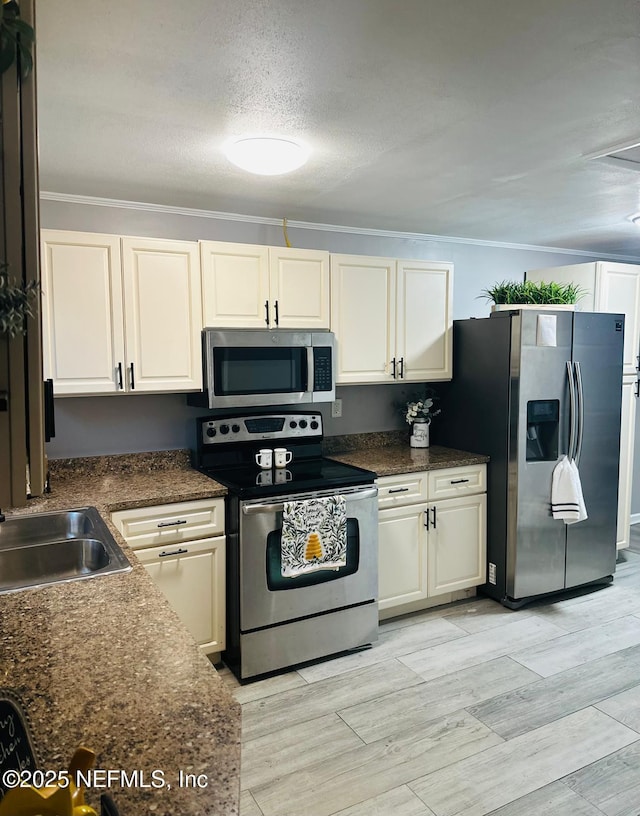 kitchen with sink, stainless steel appliances, crown molding, a textured ceiling, and light hardwood / wood-style flooring