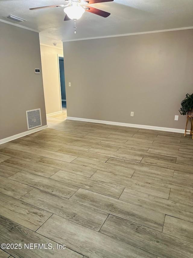 spare room with ornamental molding and ceiling fan