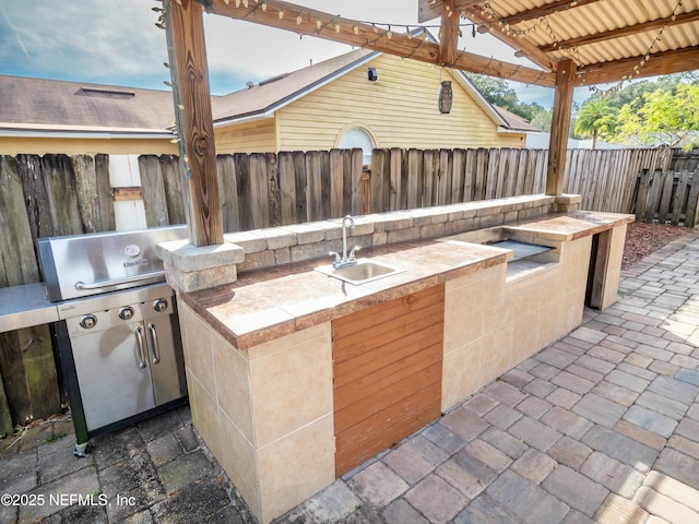 view of patio featuring exterior kitchen and sink