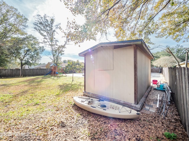 exterior space featuring a storage shed, a lawn, and a playground