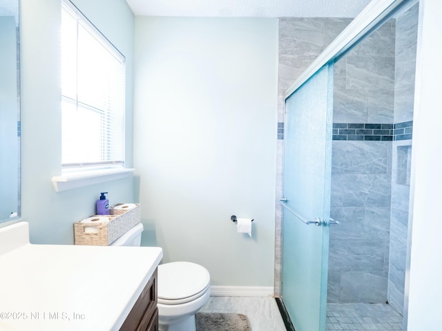 bathroom featuring vanity, toilet, and a shower with shower door