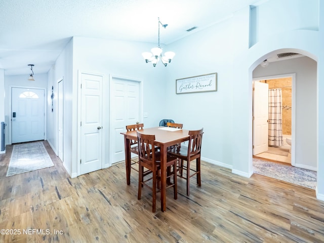 dining area featuring hardwood / wood-style floors and a chandelier