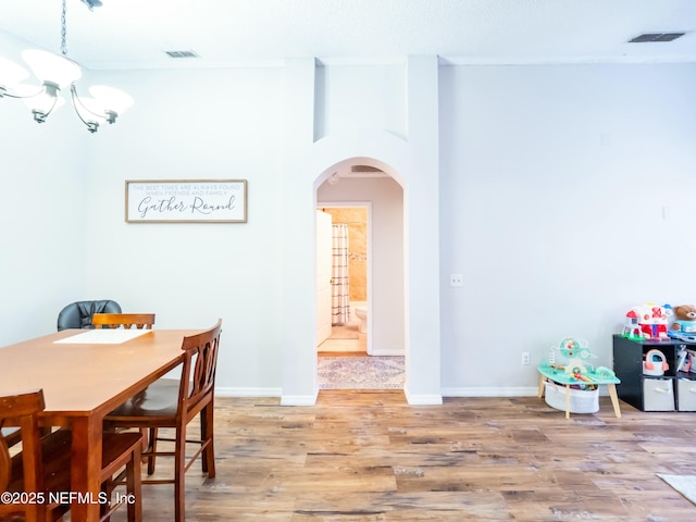 dining area featuring a notable chandelier and hardwood / wood-style floors