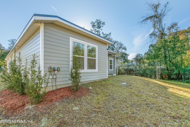 view of side of home with a yard