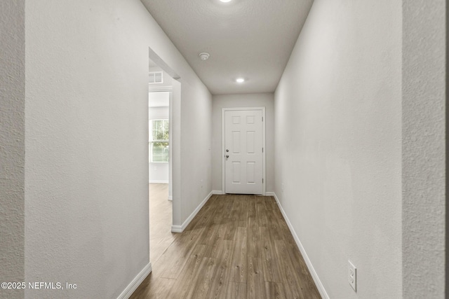 hall with hardwood / wood-style flooring