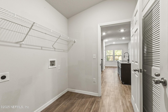 laundry area featuring hookup for a washing machine, wood-type flooring, sink, and hookup for an electric dryer